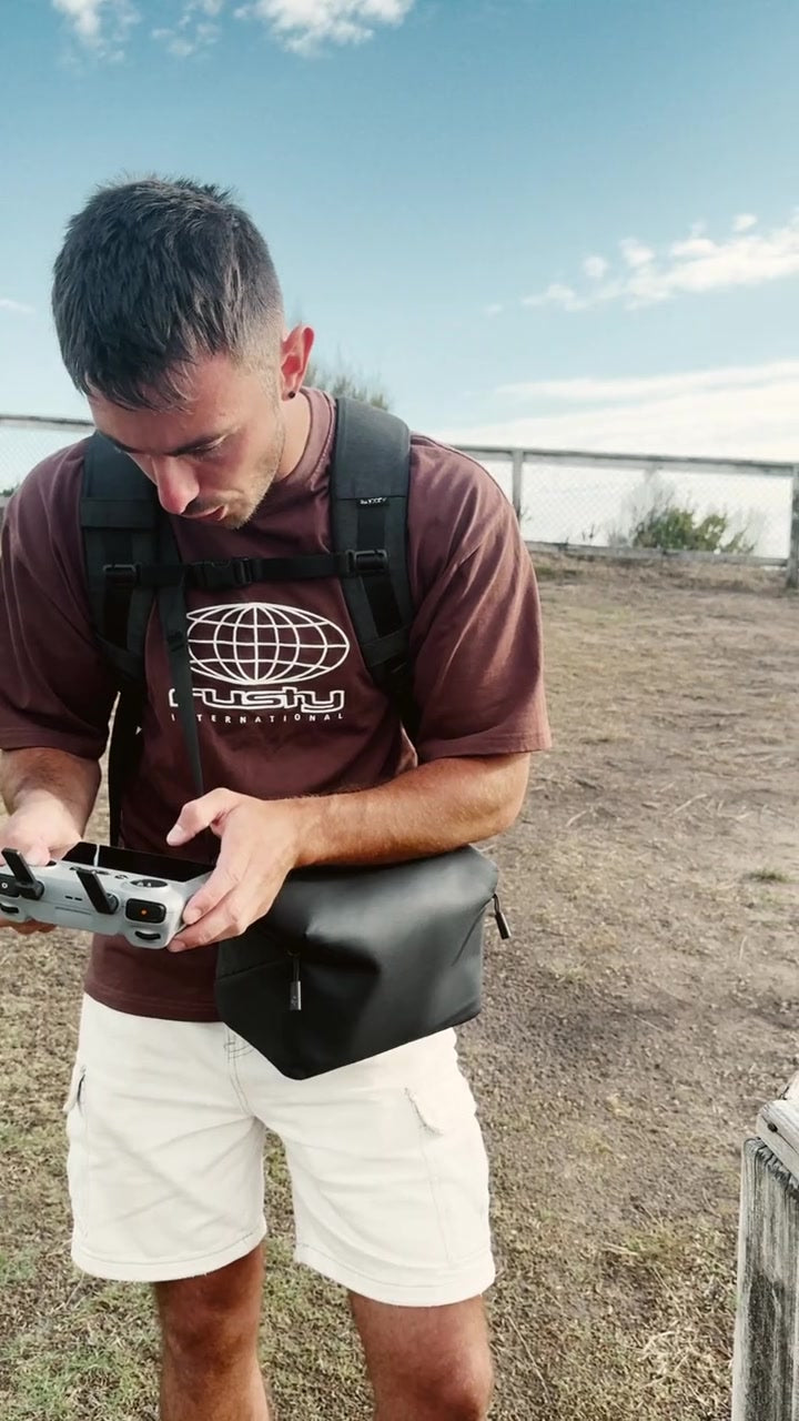 Lachie using the drone controller by the coast.